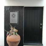 Une entrée de maison avec une porte noire et une décoration en ardoise